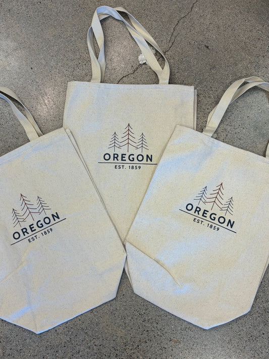 "Canvas tote bag with Oregon tree line graphic and Est. 1859 text"